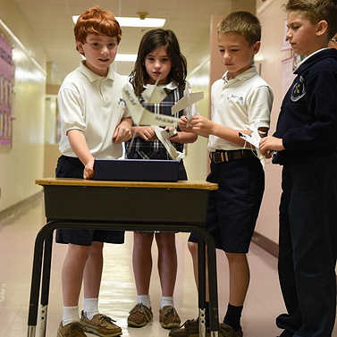 Four PLTW Launch students working together on a project
